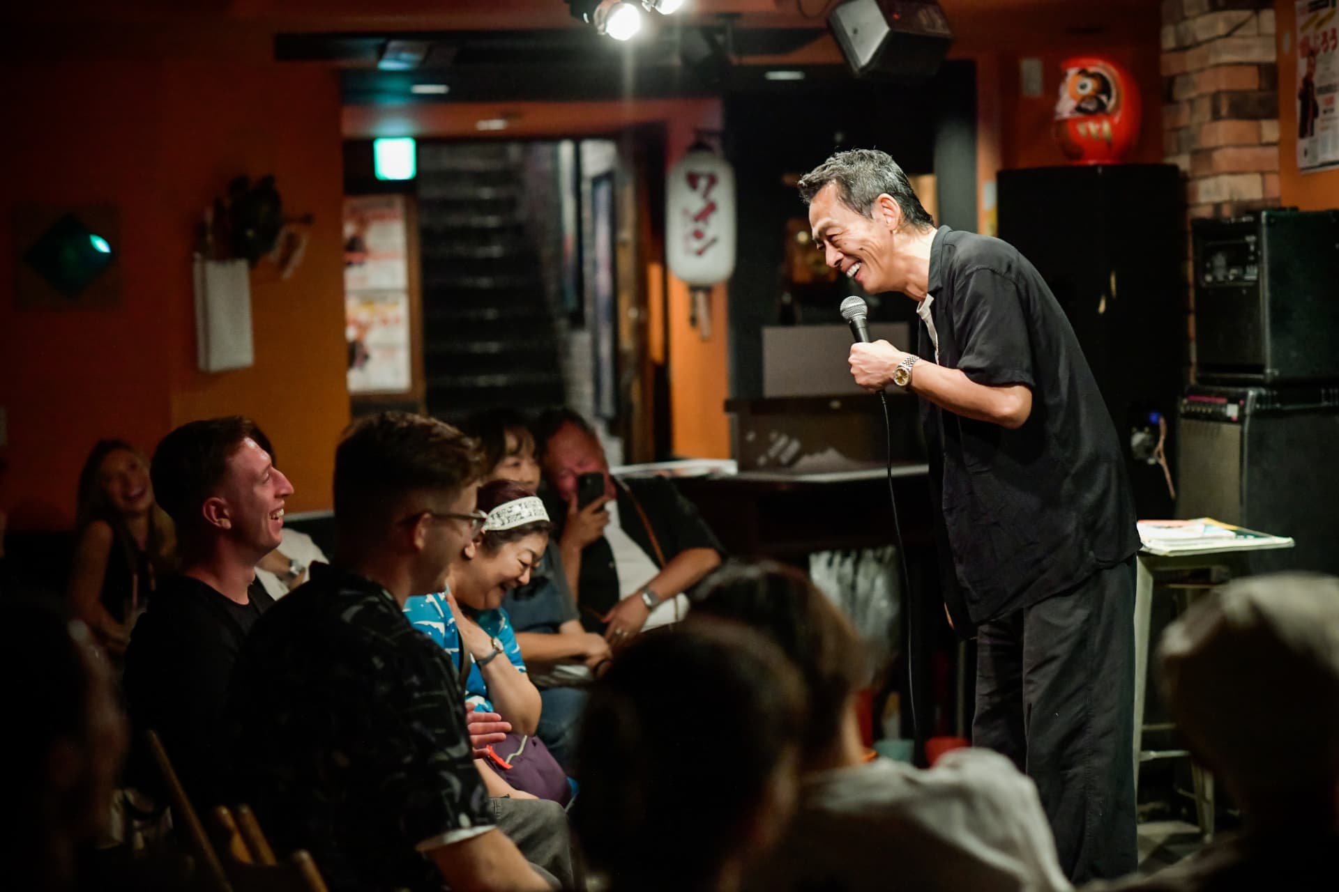 Zenjiro performing stand-up comedy live on stage in Kyoto