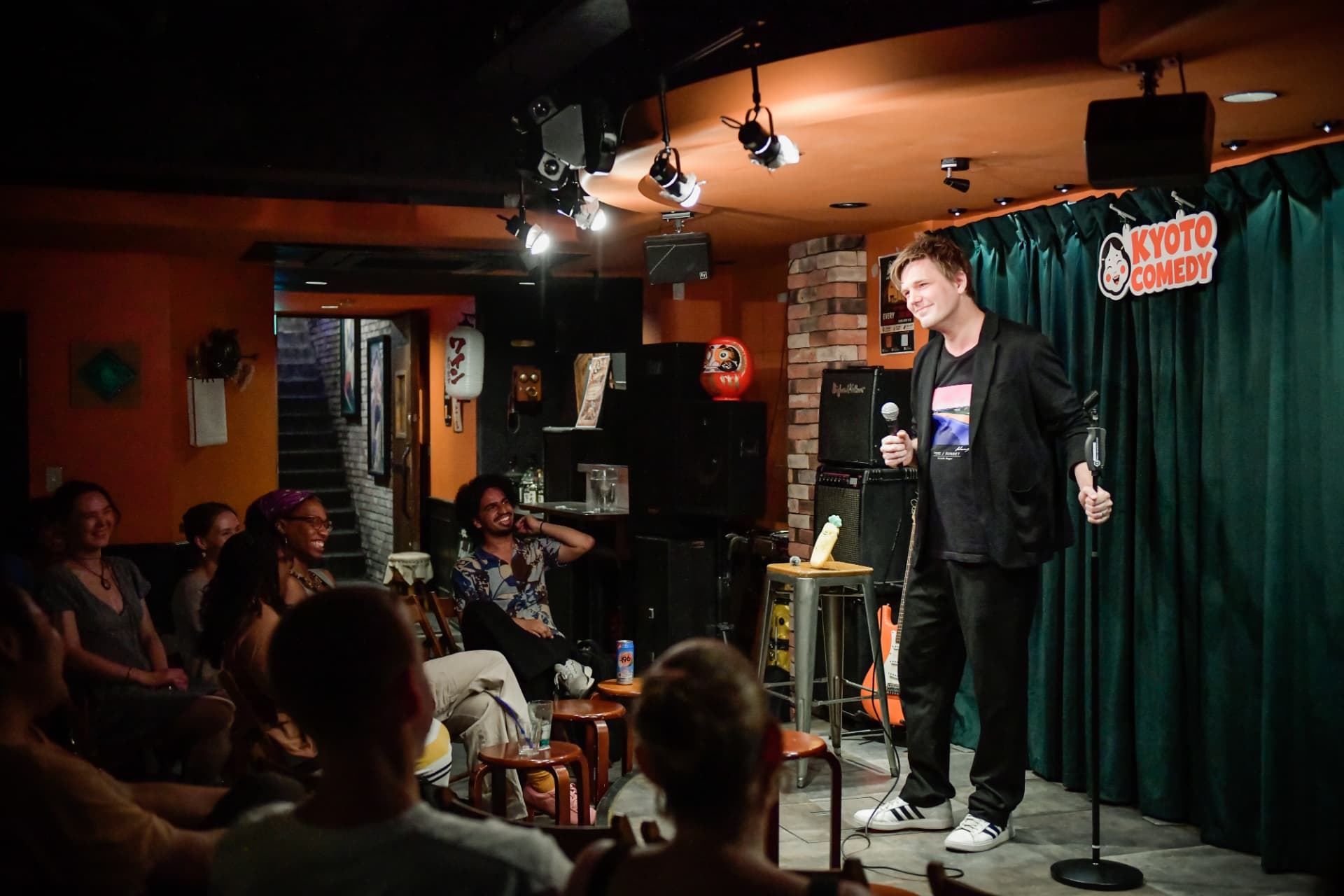 Comedian performing live on stage at a Kyoto Comedy show