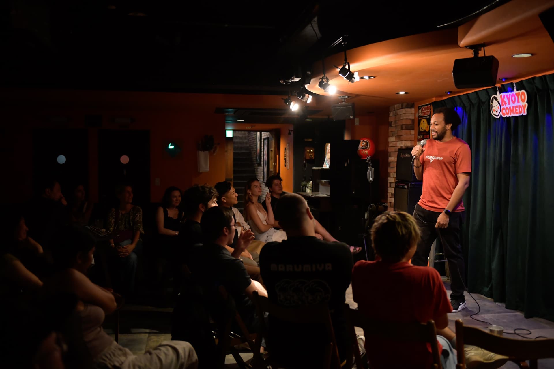 Comedian performing in front of the Kyoto Comedy backdrop