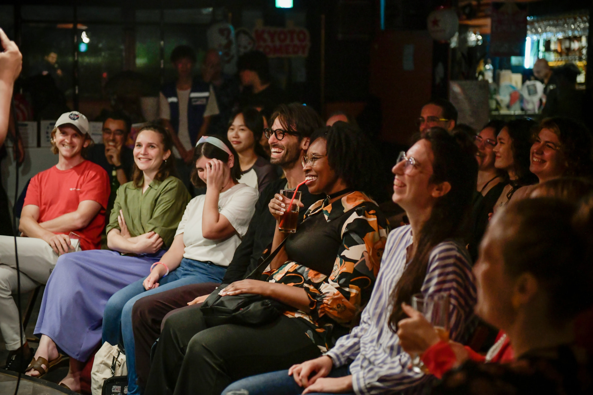 A smiling audience enjoying a Kyoto Comedy show at Ki Bar
